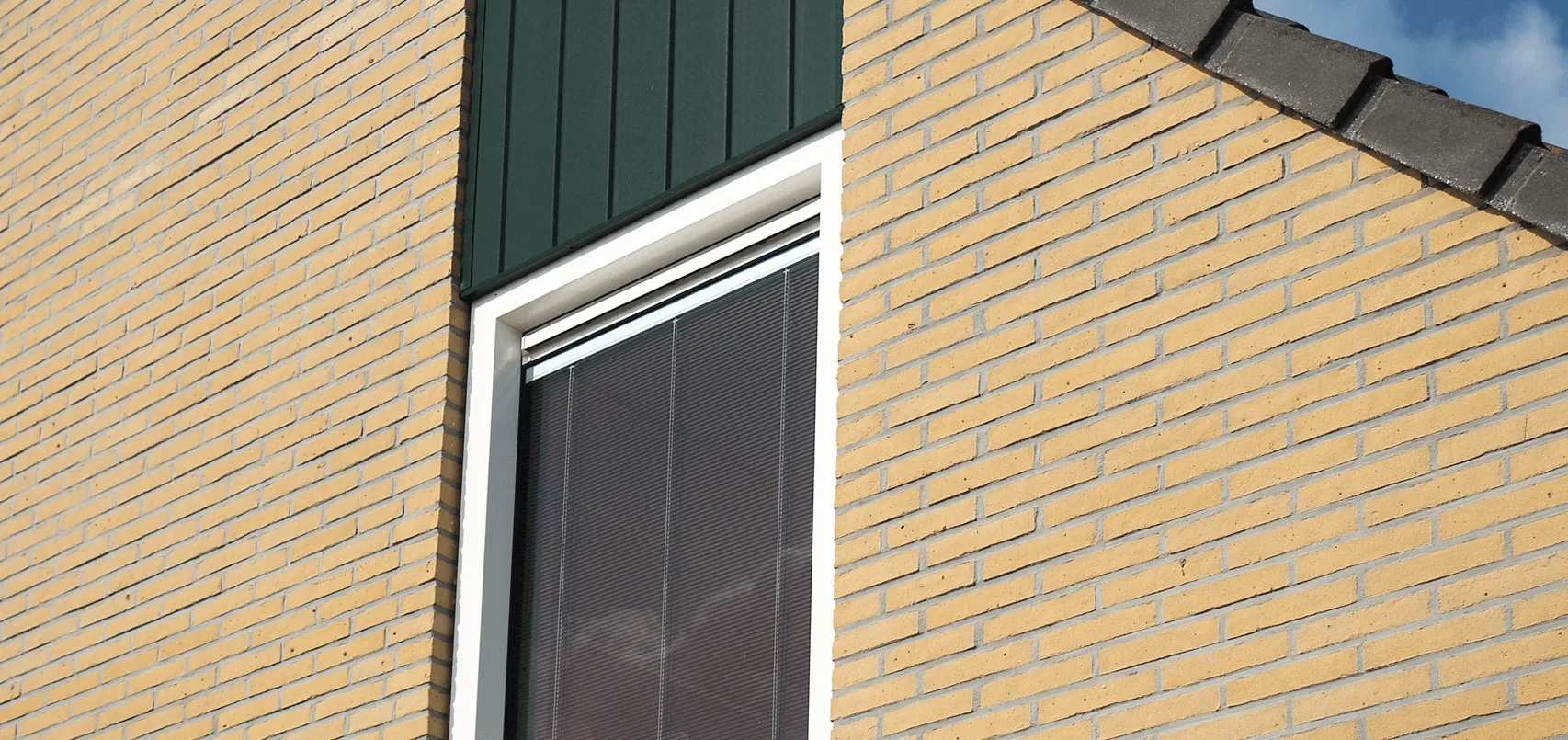Bakstenen huis met een wit kunststoffen raamkozijn