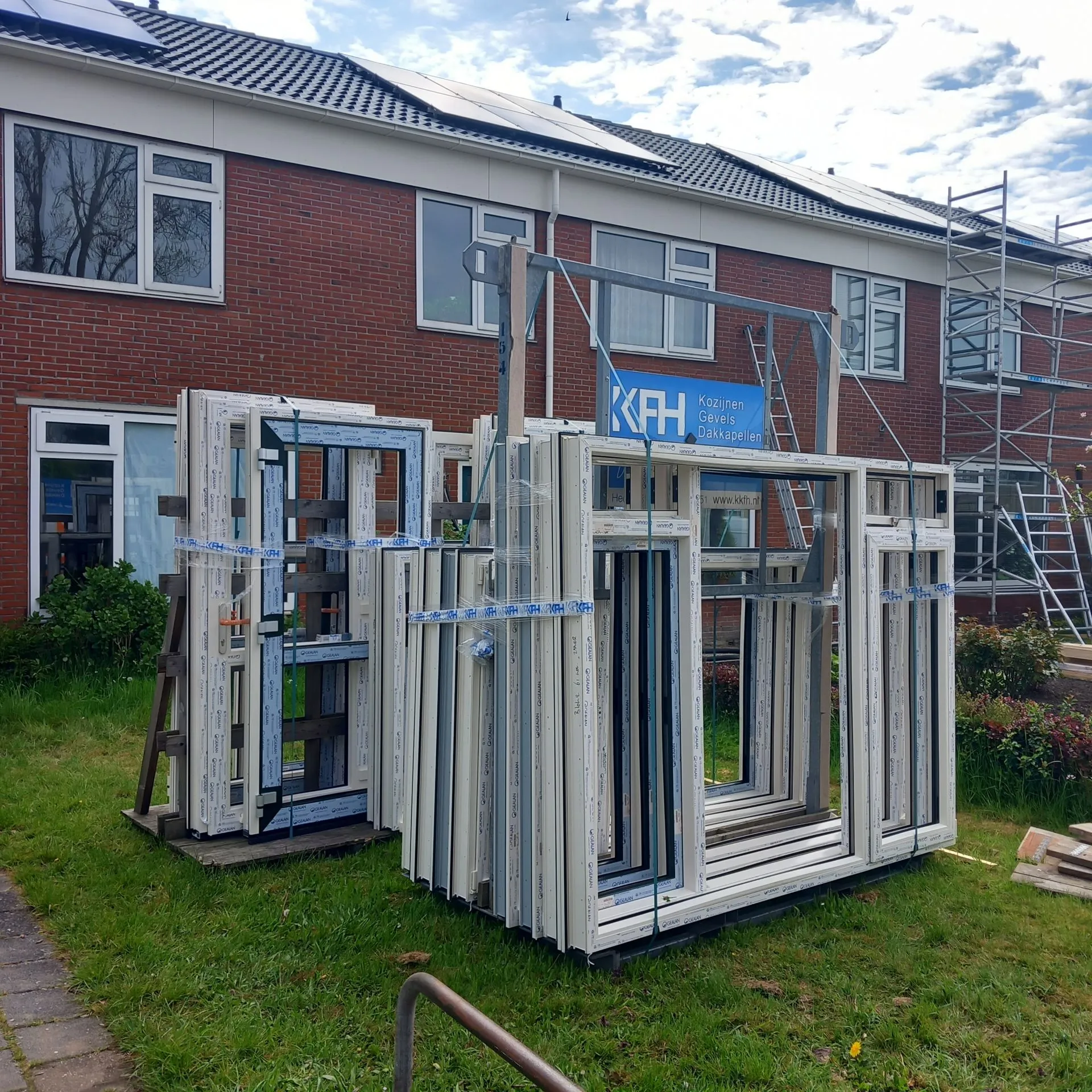 Een rijtjeswoning met nieuwe witte kunststof kozijnen van KKFH ervoor