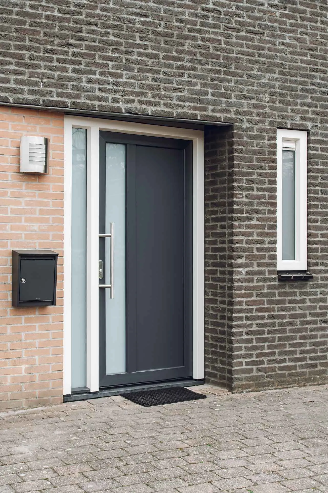 Witte kunststof kozijnen met zwarte deur in Joure